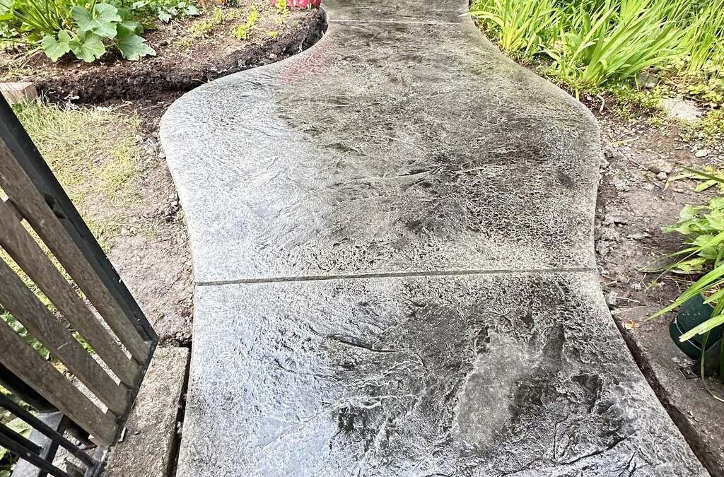 Stamped concrete textured concrete pathway in backyard